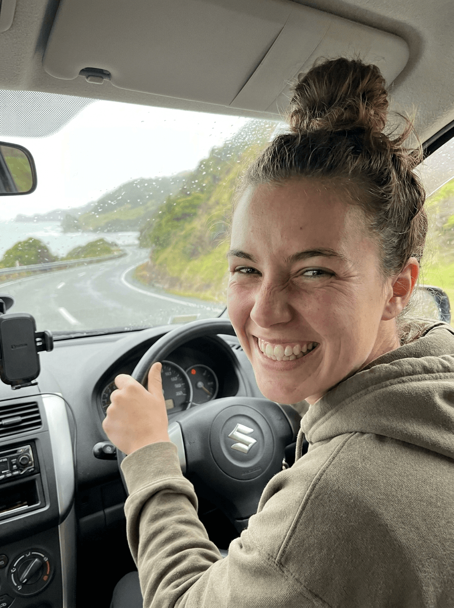 Happy Udrive customer behind the wheel on a New Zealand coastal road